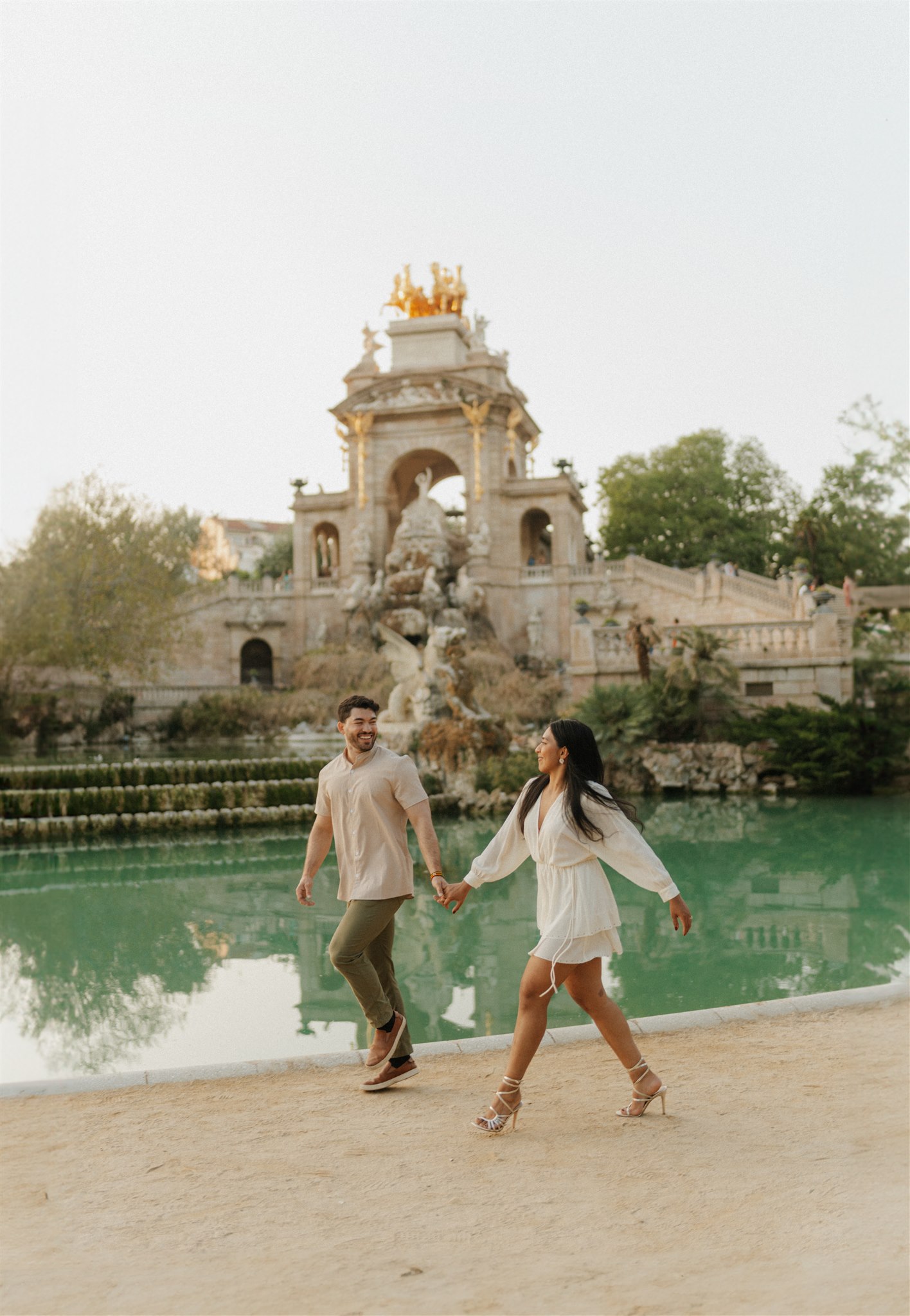 Candid walking shot of a couple in beige neutral clothing within the Ciutadella Park.